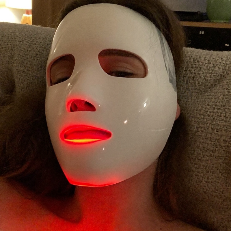 Rubralight customer using the LED mask on the couch